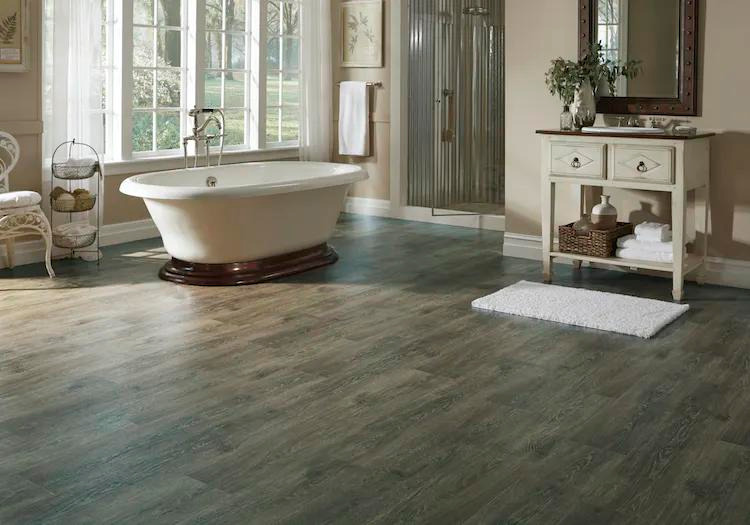 A bathtub on top of faux wood vinyl flooring