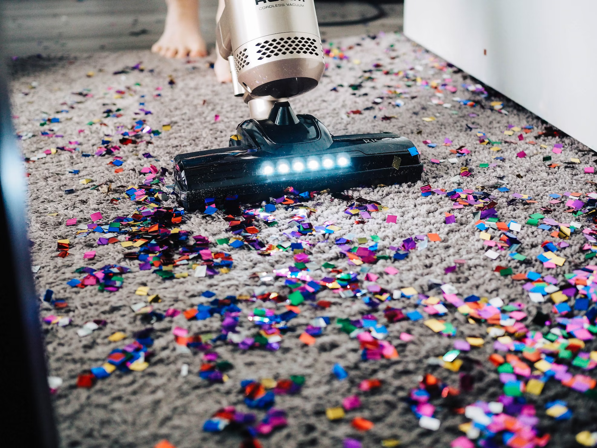 A vacuum on a carpet covered in confetti