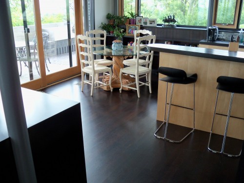 Dark hardwood floors in a kitchen with a small corner table